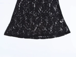 Detailed close-up of the black floral lace hem on a slim fit French style midi dress