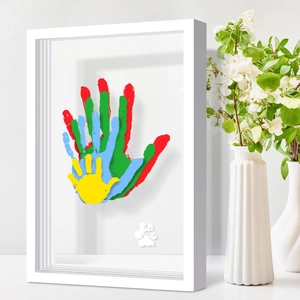 White 3D shadow box frame with colorful family handprints and pet paw print display