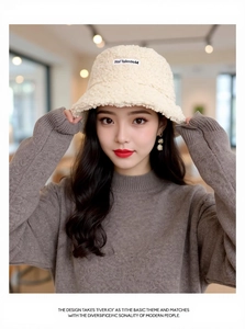 Close-up of beige faux shearling bucket hat with premium Hel Talentom fabric patch