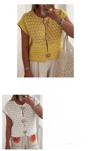 Macro detail of crochet knit vest with sun-shaped metal buttons and textured fabric finish