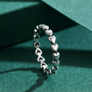 Minimalist S925 sterling silver ring with heart pattern design on textured background