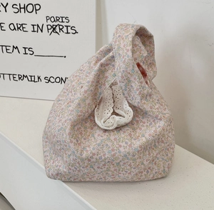 Detailed close-up of pink floral cotton handbag with lace trim and checkered lining