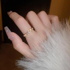 Detail of gold plated cross ring with micro-paved zircons worn on a finger