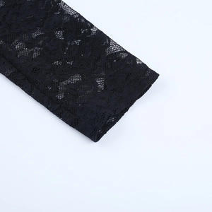 Gros plan détaillé des poignets en dentelle noire avec motifs floraux ajourés sur la manche