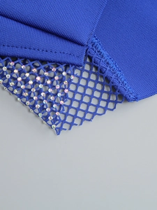 Détail d'une robe bandage bleue avec patchwork en maille et ornements en strass colorés