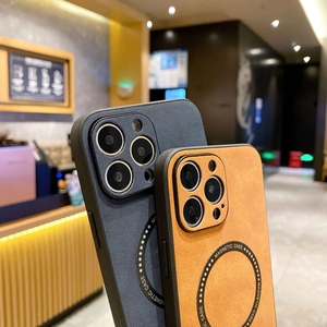 Detail of dark grey matte and orange leather textured magnetic phone cases with circular rings