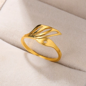 Detailed macro shot of an 18k gold plated hollow wing ring in a beige velvet jewelry box