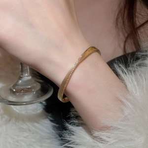 Close-up of a gold multi-layer hollow bracelet with crystals on a woman's wrist