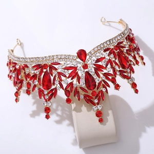 Detail of bridal gold crown featuring red gemstones and crystal leaf drop elements