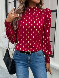 Detail view of women's red long sleeve blouse featuring elegant golden polka dot patterns
