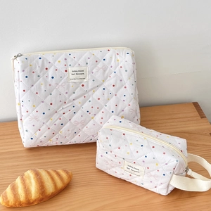 Detailed view of quilted cotton cosmetic bag set featuring colorful polka dots and bows