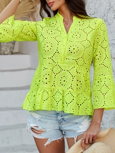 Détail de la broderie ajourée jaune néon sur un haut col V avec volants et manches 3/4