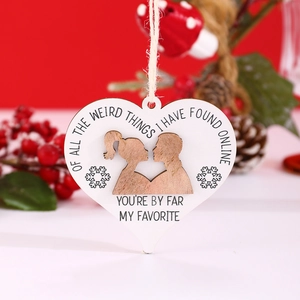 Detail of wooden heart ornament with humorous quote and rustic twine on Christmas background