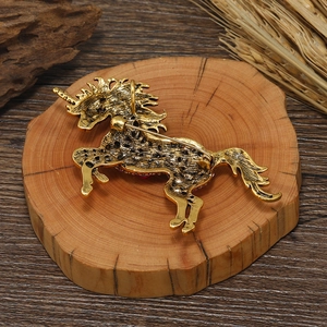 Vintage gold alloy unicorn brooch pin on a rustic wooden base with wheat decor
