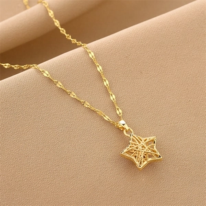 Elegant gold titanium steel necklace featuring a hollow star pendant on textured fabric