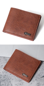 Detail view of a brown leather bi-fold men's wallet with textured pebble grain and blue stone charm