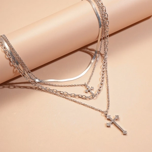 Detail of silver layered cross necklace with sparkling rhinestones and multi-link chains