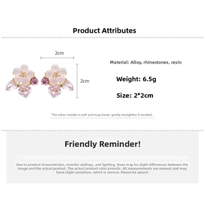 Detailed view of flower earrings with pink petals, purple crystals and silver needle posts