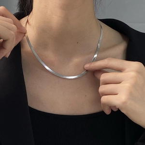Close-up of a silver titanium steel flat snake bone chain worn on a woman's neck