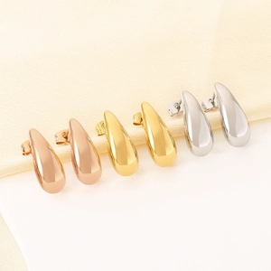Macro detail of tear drop earrings in polished 18k gold, rose gold and silver finishes
