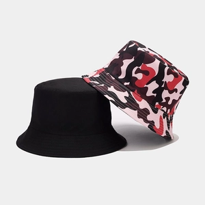 Detail showing solid black and pink camouflage bucket hats stacked in cotton canvas material
