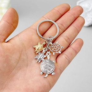 Antique silver sea turtle keychain with four turtle pendants and hollow shell design