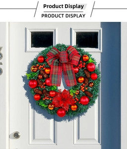 Detail of a festive Christmas wreath with red bows and ornaments on a white door