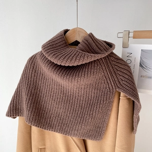 Detail of chunky knit texture and split high neck design on coffee brown poncho scarf