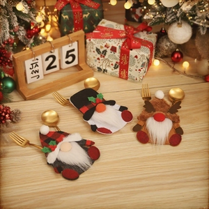 Three Christmas gnome cutlery holders on a festive wooden table with holiday decorations