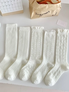 Detail von fünf weißen Baumwollsocken mit Lochmuster-Spitze und Herzstrick-Texturen