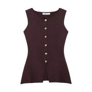 Detail of burgundy knit vest featuring golden metal buttons and classic side split hem