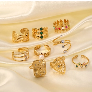 Detail of vintage gold-plated rings set featuring snake relief and pearl inlays on silk