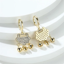 Detail of golden Ruyi lock earrings with cubic zirconia inlay and small bells