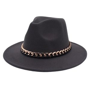Detailed close-up of dark grey fedora hat featuring a bold gold chain link decoration