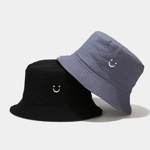 Detailed view of smiley face embroidery on high-quality black and blue canvas bucket hats