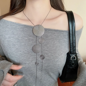Detail of geometric round textured fringe necklace with vintage silver finish on model