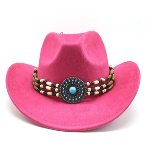 Détail du chapeau de cowboy en daim rose avec bande perlée turquoise et emblème vintage