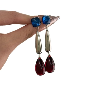 Elegant drop earrings with blue square studs and red teardrop pendants in silver finish