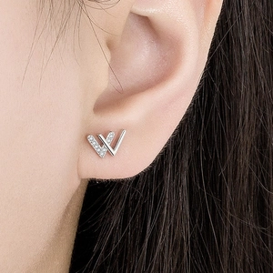 Chic silver V-shaped earrings with sparkling cubic zirconia on female model earlobe