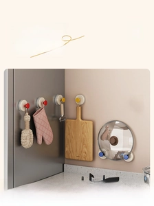Close-up of colorful suction cup wall hooks organizing wooden boards and tools in a kitchen