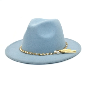 Detail eines hellblauen Wollhutes mit Goldkette, Perlenband und zwei Quastenanhängern