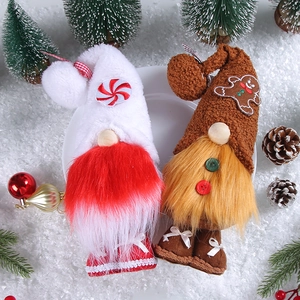 Christmas faceless gnome dolls with red knit caps and gingerbread man on white snow