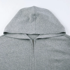 Detail eines grauen Rippstrick-Hoodies mit Metallreißverschluss und Kragendesign