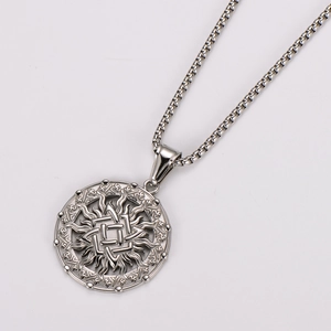 Close-up of silver stainless steel necklace featuring a round sunburst pendant on plain white