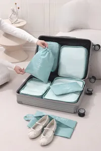 Detail of 7-piece light blue travel organizer set packed in an open gray suitcase