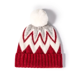 Women's winter knit beanie with stylish tricolor zigzag pattern and white fur pompom detail