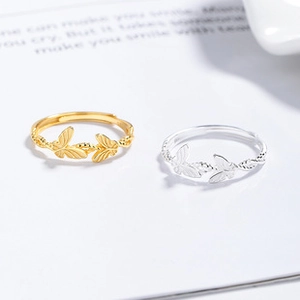 Detail of adjustable butterfly rings in gold and silver finish with metal texture