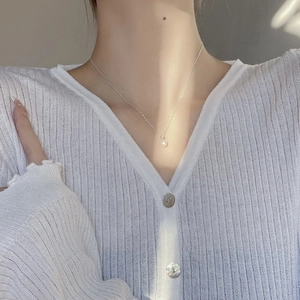 Close-up of a high-quality natural freshwater pearl necklace on a silver chain on neck