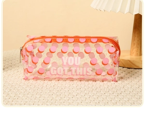 Close-up of a clear PVC makeup bag with pink dots and You Got This slogan