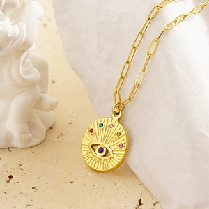 Golden paperclip chain necklace with colorful zircon evil eye pendant in artistic setting